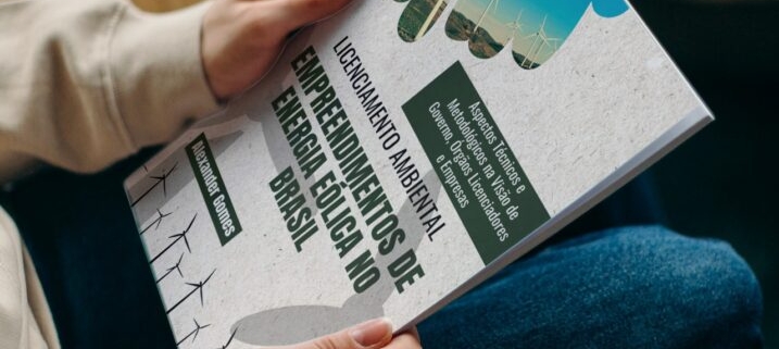 Pessoa segurando livro Empreendimentos de Energia Eólica no Brasil